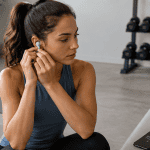 Femme ajuste écouteurs musique fitness salle de sport